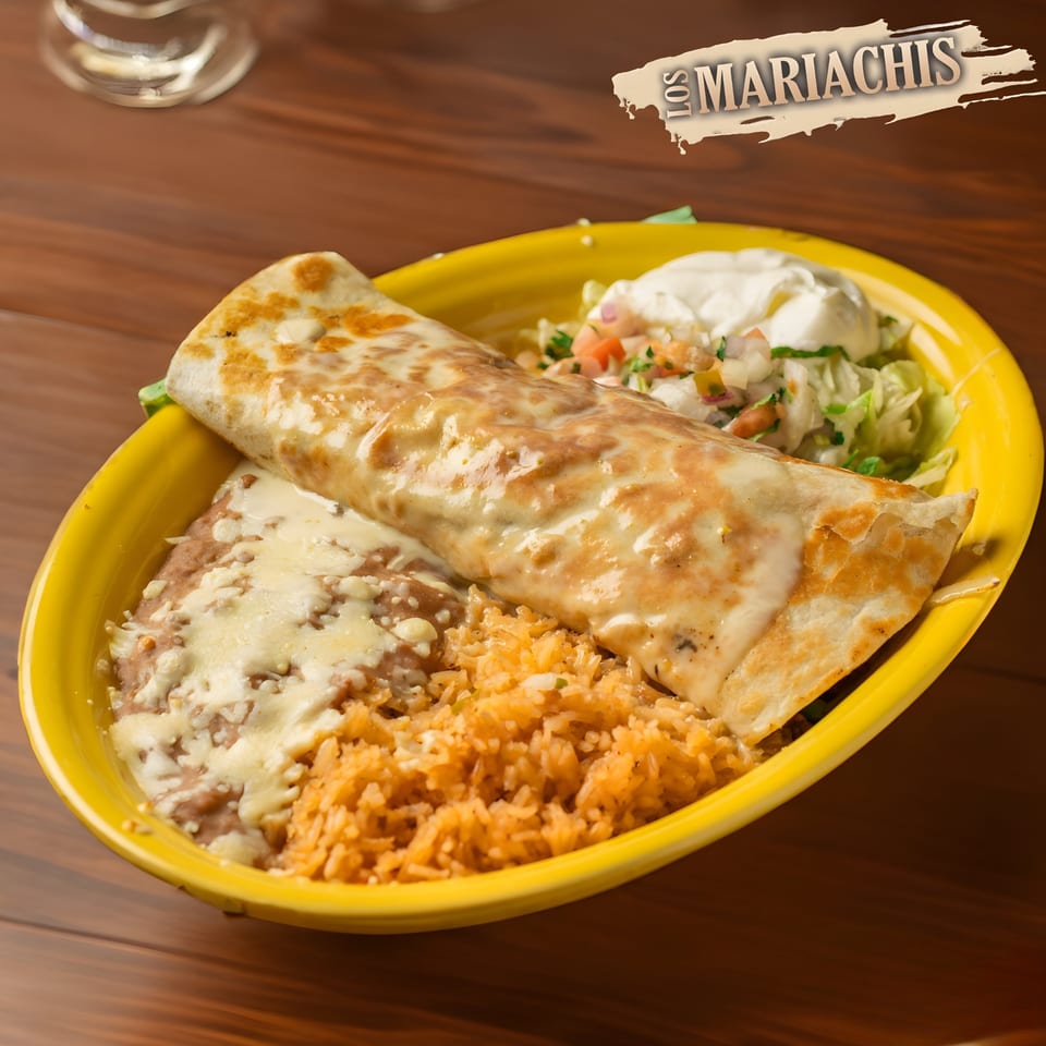 A Los Mariachis burrito covered in cheese sauce, with rice, refried beans, and salad.